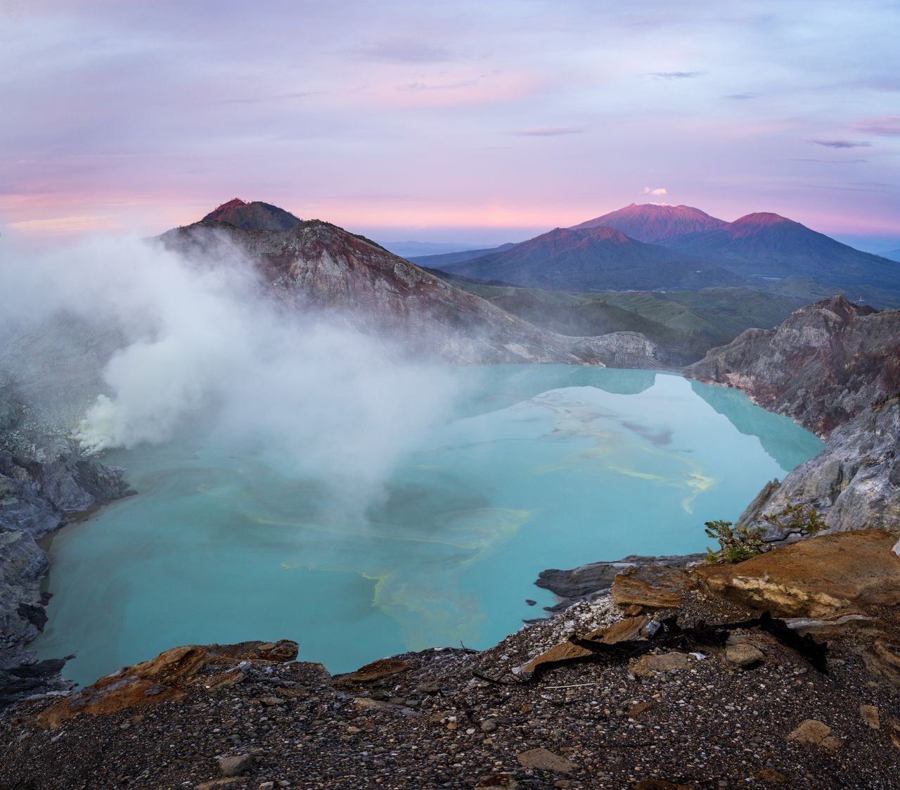 Services Amazing scenery of mountain ridge and hot spring with turquoise water under bright sunset sky