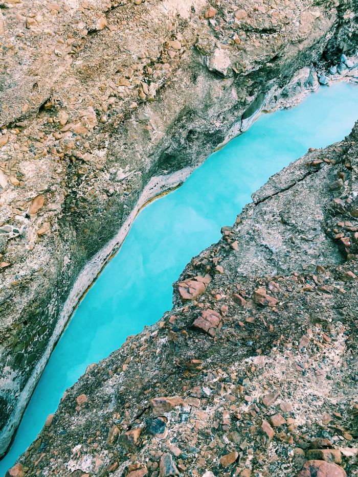 Services A stunning view of a turquoise river cutting through rocky formations, creating a serene and scenic landscape.