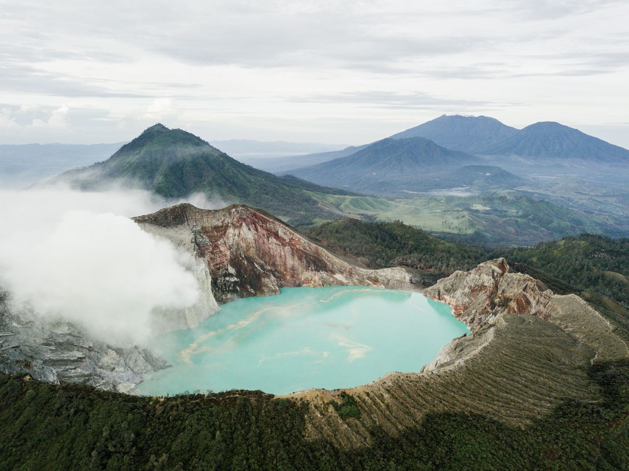 The Art of Drawing Readers In: Your attractive post title goes here Stunning aerial view of the turquoise Kawah Ijen Crater Lake with smoky surroundings.
